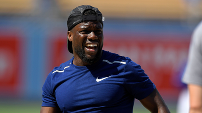Actor Kevin Hart talks during taping for an episode for Hart's TV series "What the Fit" during batting practice prior to baseball game between the Los Angeles Dodgers and the Milwaukee Brewers Thursday, Aug. 2, 2018, in Los Angeles. (AP Photo/Mark J. Terrill)