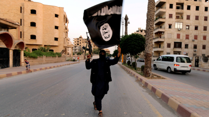 A member loyal to the Islamic State in Iraq and the Levant (ISIL) waves an ISIL flag in Raqqa June 29, 2014. The offshoot of al Qaeda which has captured swathes of territory in Iraq and Syria has declared itself an Islamic "Caliphate" and called on factions worldwide to pledge their allegiance, a statement posted on jihadist websites said on Sunday. The group, previously known as the Islamic State in Iraq and the Levant (ISIL), also known as ISIS, has renamed itself "Islamic State" and proclaimed its leader Abu Bakr al-Baghadi as "Caliph" - the head of the state, the statement said.