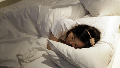 A woman sleeps on a bed