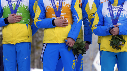 Ukraine's athletes cover their silver medals with hands after finishing second in cross country 4x2.5km open relay at the 2014 Winter Paralympic, Saturday, March 15, 2014, in Krasnaya Polyana, Russia. The majority of Ukraine's Paralympic medalists covered their medals during medal ceremonies. (AP Photo/Dmitry Lovetsky)