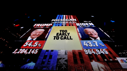 A giant television screen shows a network TV broadcast showing the U.S. presidential race