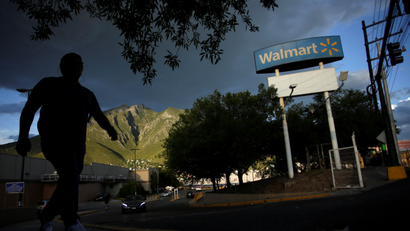 A man walks by Walmart sign outside one of their stores in Monterrey, Mexico