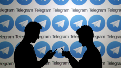Two men pose with smartphones in front of a screen showing the Telegram logos in this picture illustration taken in Zenica, Bosnia and Herzegovina November 18, 2015. The mobile messaging service Telegram, created by the exiled founder of Russia's most popular social network site, has emerged as an important new promotional and recruitment platform for Islamic State. The service, set up two years ago, has caught on in many corners of the globe as an ultra-secure way to quickly upload and share videos, texts and voice messages. It counts 60 million active users around the world. Picture taken November 18.