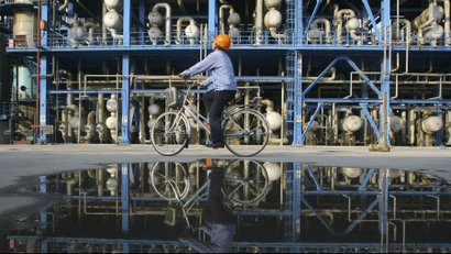 An engineer on a bicycle checks pipelines at a PetroChina's oil refinery in Lanzhou, Gansu province.