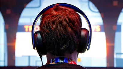 A gamer wears headphones while playing a game at the 2014 Electronic Entertainment Expo, known as E3, in Los Angeles, California June 10, 2014.