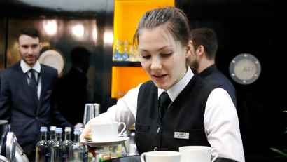 A waitress works at the bar on the stand of Hyatt Hotels