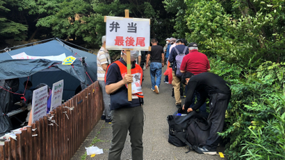People line up for food handouts in Tokyo, Japan.