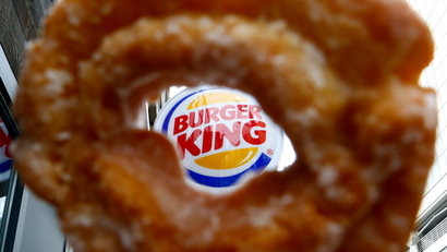 The Burger King logo is seen through a Tim Horton's doughnut hole in a photo illustration outside a restaurant in Toronto August 29, 2014. Burger King's proposed $11.5 billion acquisition of Canada's Tim Hortons may offer big tax benefits to the U.S. fast food chain but the real tax winner is likely to be its controlling shareholder, 3G Capital. The New York investment firm is not only deferring a capital gains tax hit in the U.S. because of the deal structure, but is also poised to reap a multitude of dividend tax and other benefits by moving Burger King's domicile to Canada, tax experts on both sides of the border said.