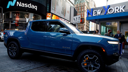 A blue Rivian pickup truck is pictured outside the Nasdaq stock exchange.