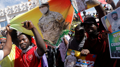 Malians demonstrate on the street carrying flags in support of the military government that seized power in the country