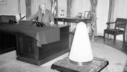 President Dwight D. Eisenhower, in his White House office, looks toward the nose cone of an experimental missile which he said had been hundreds of miles to outer space and returned to earth completely intact, Nov. 7, 1957. The president spoke on a nationally televised broadcast on the subject of Science and Security.