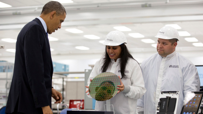 U.S. President Barack Obama is reflected in a silicon wafer during a tour of Applied Materials in Austin, Texas, May 9, 2013.