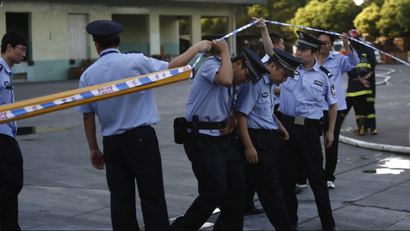 Policemen through a cordon at an entrance of a refrigeration unit of Shanghai Weng's Cold Storage Industrial Co. Ltd. in the Baoshan district of Shanghai August 31, 2013. A liquid ammonia leak from the refrigeration unit at the cold storage facility in Shanghai on Saturday has killed 15 people and injured 26 others, local authorities said. The leak occurred at 10:50 am local time (0250 GMT) at Shanghai Weng's Cold Storage Industrial Co. Ltd., located in the Baoshan district of eastern Shanghai, the Shanghai municipal government said on its official Sina Weibo account. REUTERS/Aly Song