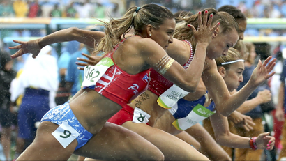 A line of Olympic hurdlers running.