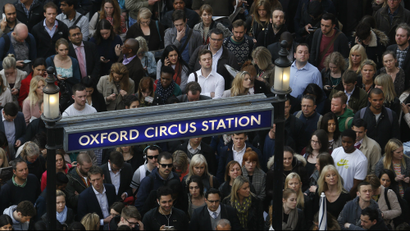 Commuters and shoppers queue for access to Oxford Circus underground station.