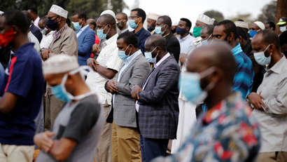 Family members and friends of Abdullahi Adan, 52, who died due to coronavirus, pray before his funeral in Nairobi.