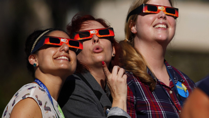 Women gaze up to view a partial solar eclipse outside the Reuben H. Fleet Science Center in San Diego, California.