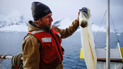 Greenpeace activist Grant Oakes shows a water sample collected using a manta trawl in Neko Harbour, Antarctica, February 16, 2018. Picture taken February 16, 2018. REUTERS/Alexandre Meneghini - RC1B04B8EB50