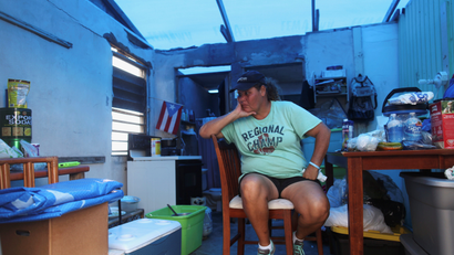 Morales sits in her kitchen without power and with a plastic sheet replacing the roof, in Yabucoa