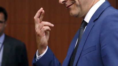 Eurogroup chairman Dijsselbloem crosses his fingers as he listens to Greece's Finance Minister Varoufakis during euro zone finance ministers meeting in Brussels