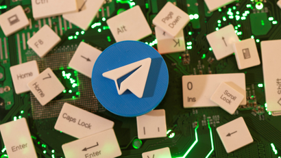 Telegram's paper airplane logo is displayed against a backdrop of scattered keys from a keyboard.