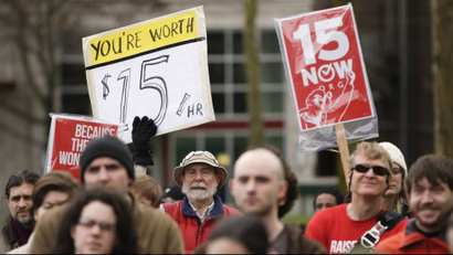 People rally in support of a $15 minimum wage at Seattle Central Community College in Seattle, Washington.