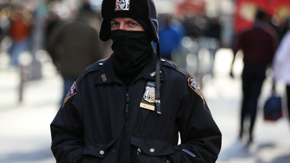 A New York Police Department (NYPD) officer bundles up against the cold temperature as he walks in Times Square in New York
