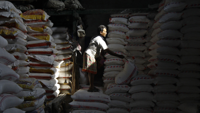 A labourer writes serial number on a sack filled with flour at a wholesale market in Kolkata