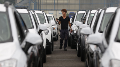 A worker checks cars made by GM Korea in a yard of GM Korea's Bupyeong plant before they are transported to a port for export, in Incheon, west of Seoul August 9, 2013. General Motors Co. has begun gradually cutting its presence in South Korea after mounting labor costs and militant unionism triggered a rethink of its reliance on the country for a fifth of its global production, three individuals familiar with GM's thinking said. Picture taken August 9, 2013. REUTERS/Lee Jae-Won