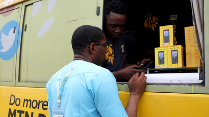 A customer being attended to from the window of a bus by an MTN agent