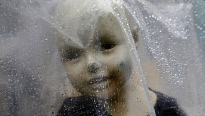 A mannequin is covered with a plastic sheet to prevent from rains outside a garments store in Mumbai, India, Saturday, June 23, 2018. India's western state of Maharashtra enforced its state-wide ban on a wide range of single-use plastic items including disposable cutlery and thermocol. (AP Photo/Rajanish Kakade)