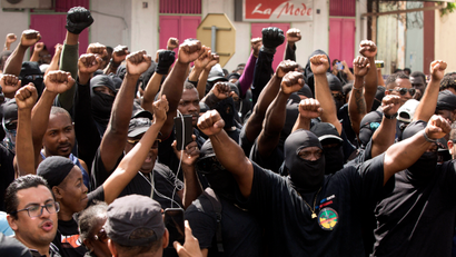 FILE - In this Tuesday, March 28, 2017 file picture, masked members of the collective "500 Brothers" take part in a march supporting a general strike in Cayenne, French Guiana. French government calls on protesters in French Guiana to lift the roadblocks after a 1 billion euro government plan to help the South American territory has been presented during Cabinet meeting.