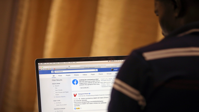 A man opens the Facebook page on his computer to fact check Covid-19 information, in Abuja.