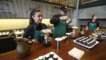 Workers prepare coffee during the inauguration of Starbuck's first Colombian store at 93 park in Bogota July 16, 2014. Starbucks Corp opened its first shop in Colombia on Wednesday, 43 years after the world's biggest coffee chain first started buying beans from the country famous for its premium arabica coffee named after fictional coffee farmer Juan Valdez.