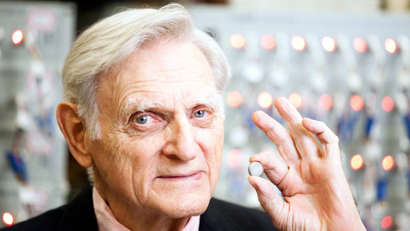 In this undated photo provided by the University of Texas at Austin, John Goodenough, godfather of the lithium ion battery, poses for photos with one of his devices. Goodenough, 90, is the man responsible for the 1979 breakthrough that led to the first commercial lithium ion battery in 1991. He will receive the National Medal of Science at the White House next month.