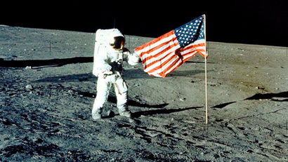 File photo of NASA astronaut Conrad Jr. standing with the U.S. flag on the lunar surface