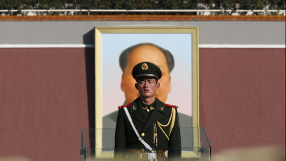 A Paramilitary soldier stands guard behind a chain as the giant portrait of the late Chinese Chairman Mao Zedong is seen in the background on the Tiananmen square next to the Great Hall of the People where the Chinese Communist Party plenum is being held in Beijing, November 12, 2013. China's leaders will unveil a reform agenda for the next decade on Tuesday, seeking to balance the need to overhaul the world's second-largest economy as it loses steam with preserving stability and to reinforce the Communist Party's power. REUTERS/Kim Kyung-Hoon