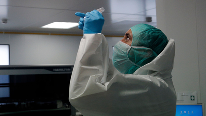A forensic scientist of the Criminal Research Institute of the National Gendarmerie (IRCGN), in Pontoise, collects DNA taken from the victims of the crash of the Germanwings Airbus A320 in the French Alps, March 30, 2015. Forensic scientists are in the active phase in the identification process of the 150 victims in the air crash.