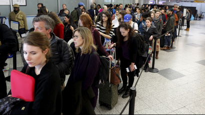 Travelers wait in line at a security checkpoint at La Guardia Airport in New York November 25, 2015.
