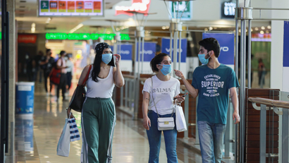 People wearing masks walk with shopping bags inside a mall as India eases lockdown restrictions that were imposed to slow the spread of the coronavirus disease (COVID-19), in New Delhi