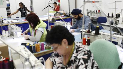 Employees work on sewing machines at the Fashion Enter factory in London.