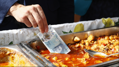 Mark Carney dips UK's new £5 note in food