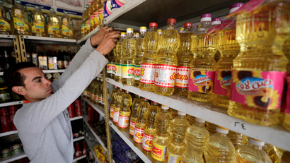 Man reaches for products at a supermarket aisle with vegetable oil in Cairo