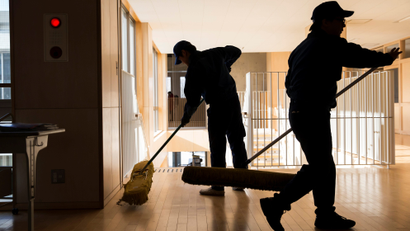 Two men mopping a floor