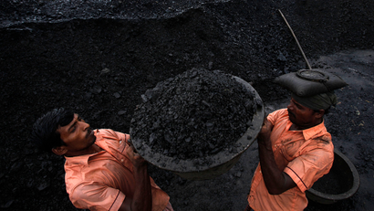 Laborers load coal onto a truck at a coal depot in Gauhati, India