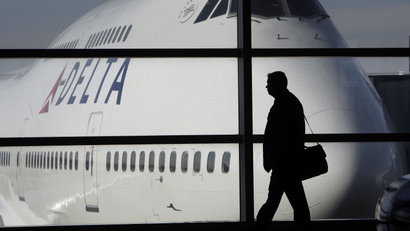 A passenger walks past a Delta Airlines 747 aircraft in McNamara Terminal at Detroit Metropolitan Wayne County Airport in Romulus, Mich.