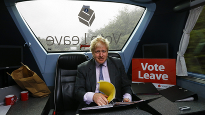 Former London Mayor Boris Johnson works in the back of the Vote Leave bus as it heads towards Exeter