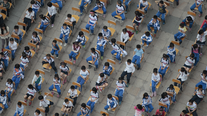 Students from different classes attend an outdoor joint lesson outside a school building in Guangzhou, Guangdong province April 18, 2014.