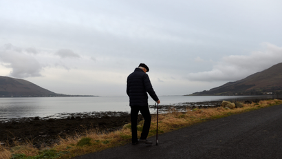 An older man walks a path in Ireland