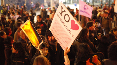 At a protest, a woman holds a sign saying I heart misoprostol
